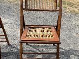 two wooden chairs sitting next to each other on a gravel ground