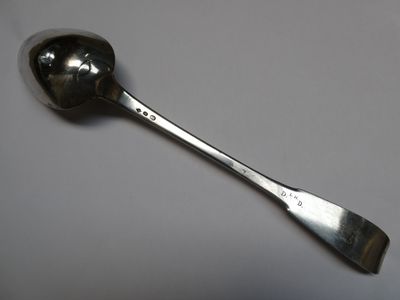 une cuillère sur laquelle se trouve une autre cuillère, posée sur une table