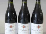 trois bouteilles de vin rouge sont alignées sur une table