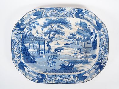 une assiette bleue et blanche avec un paysage dessus