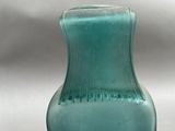 a blue glass vase sitting on top of a table