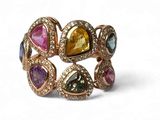 une photo en gros plan d'une bague sertie de pierres de différentes couleurs