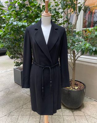 une image d'un manteau noir sur un support de mannequin