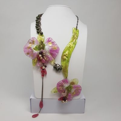 purple and green flower necklace and earring set on a white mannequin