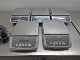 three electronic scales sitting on top of a metal table