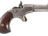 gros plan d'un pistolet avec une poignée en bois sur fond blanc