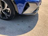 a close up of a blue car parked in a parking lot