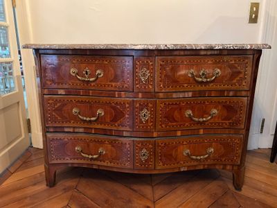 a wooden dresser with marble top in a room