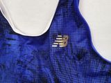 the back of a blue and white sports bra top with a gold logo on it