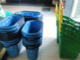 many blue and green bins sitting on the floor next to each other