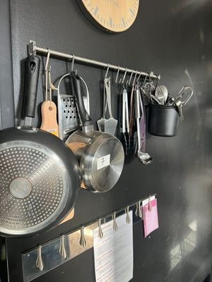 de nombreuses casseroles et poêles accrochées au mur