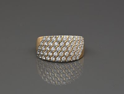 un gros plan d'une bague en or et diamants posée sur une surface réfléchissante