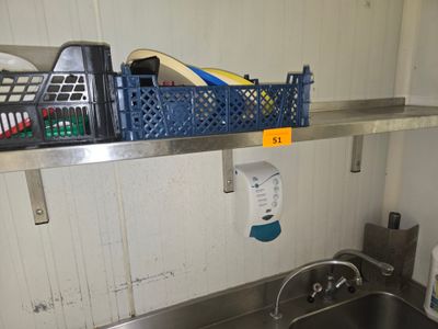 un évier de cuisine surmonté d'une étagère en métal