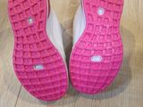pink and white tennis shoes on a wooden floor next to a box