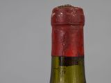 a bottle of wine that has a red cap on it