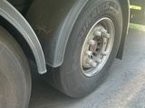 a flat bed trailer with a flat tire on the road