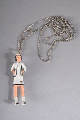 a necklace with a figurine of a woman holding a tennis racquet