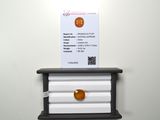 an orange ball sitting on top of a shelf next to a business card