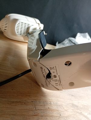 une machine à coudre blanche posée sur une table en bois