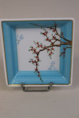 une assiette bleue et blanche ornée de fleurs rouges