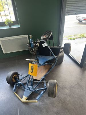 a go kart in the garage of a car repair shop