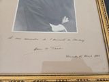 an old picture of a man in a suit and tie holding a book