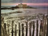 a picture of a picture of a beach with a lighthouse in the background