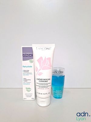 two bottles of lancomine and a tube of toothpaste on a table