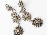 a pair of silver earrings with flowers on them