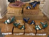 Plusieurs cartons de chaussures sont empilés les uns sur les autres sur un plancher en bois