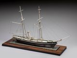 une image représentant une maquette de bateau posée sur un socle en bois