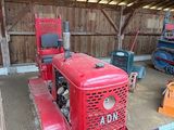 un tracteur rouge garé dans une grange