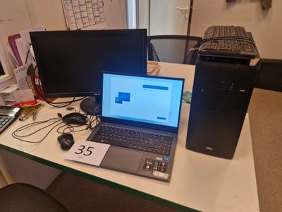 un ordinateur portable posé sur un bureau, à côté d'un écran d'ordinateur