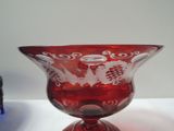 a red glass vase sitting on top of a white table