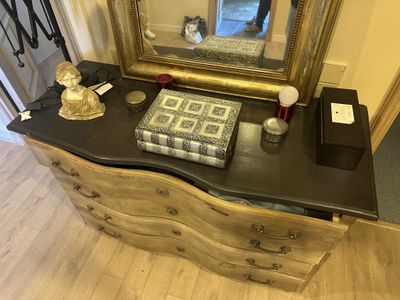 a dresser with a mirror and a book on it