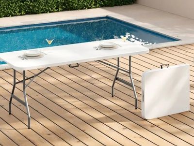 a table that is on a wooden deck near a pool