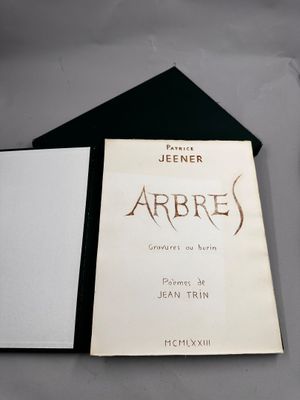 un livre en noir et blanc posé sur une table, à côté d'une paire de ciseaux