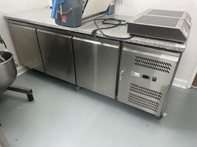 a kitchen with a stainless steel refrigerator and a mixer on the counter