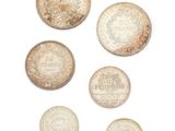 six types de pièces différents sont présentés sur une surface blanche