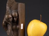 sculpture of a woman holding a child and an apple next to a book