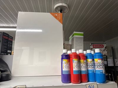 de nombreuses couleurs de peinture différentes sur une étagère dans un magasin