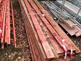 une voiture blanche garée à côté d'un tas de bois