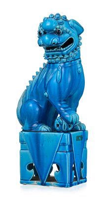 statue bleue représentant un chien posé sur une boîte et entouré d'une chaîne