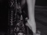 a black and white photo of a woman ' s legs in high heels
