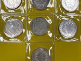 six types différents de pièces en argent dans une boîte transparente