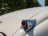 a close up of a white car with a red light on it
