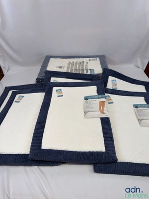 quatre serviettes sont empilées les unes sur les autres sur un lit