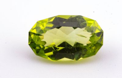 un gros plan d'une pierre précieuse verte sur une surface blanche
