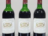 three bottles of wine are lined up on a white surface