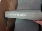 une main tenant un livre devant une boîte